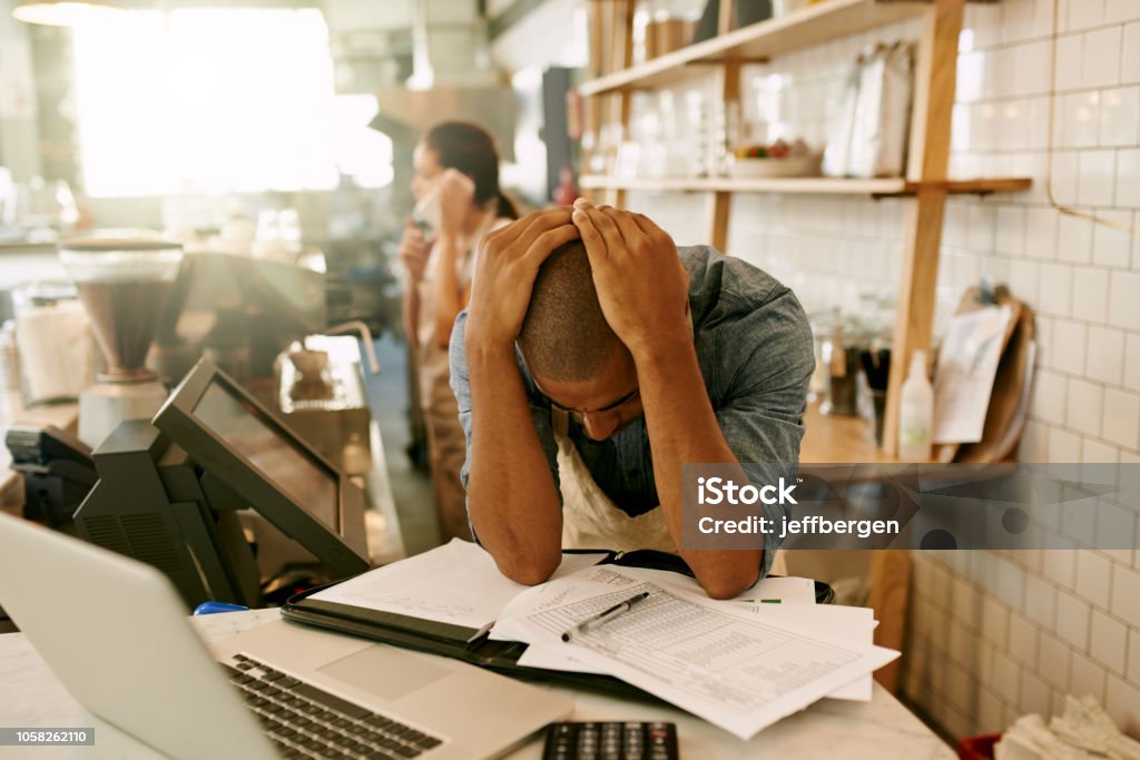 Stressed business owner overwhelmed with paperwork